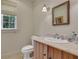 Cozy powder room featuring a wooden vanity, stone countertop, and decorative mirror at 6 Arden Moor Nw, Atlanta, GA 30305