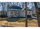 Two-story brick home with front porch and attached garage, nestled amongst mature trees at 1496 Sweet Bottom Sw Cir, Marietta, GA 30064