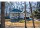 Two-story brick home with front porch and attached garage, nestled amongst mature trees at 1496 Sweet Bottom Sw Cir, Marietta, GA 30064