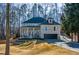 Two-story brick home with front porch and attached garage, nestled amongst mature trees at 1496 Sweet Bottom Sw Cir, Marietta, GA 30064
