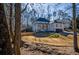 Two-story brick home with front porch and attached garage, nestled amongst mature trees at 1496 Sweet Bottom Sw Cir, Marietta, GA 30064