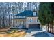 Two-story brick home with front porch and attached garage, nestled amongst mature trees at 1496 Sweet Bottom Sw Cir, Marietta, GA 30064