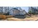 Two-story brick home with front porch and attached garage, nestled amongst mature trees at 1496 Sweet Bottom Sw Cir, Marietta, GA 30064