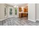 Cozy dining area featuring new gray wood-style flooring, chandelier, and natural light from the door and windows at 407 Red Coat Ln, Woodstock, GA 30188