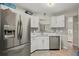 Bright kitchen features stainless steel appliances, white cabinets, quartz countertops, and tile backsplash at 5076 Furlong Way, Powder Springs, GA 30127