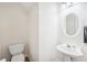 Small powder room with pedestal sink and toilet at 718 Surrey Park Se Pl, Smyrna, GA 30082