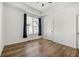 Bright bedroom with tray ceiling, wood floors, and large window with pleated blinds at 720 Perch Pl, Atlanta, GA 30312