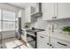 Bright kitchen featuring stainless steel appliances, white cabinetry and a tile backsplash at 720 Perch Pl, Atlanta, GA 30312
