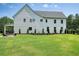 Lush backyard featuring a rear view of the house, showcasing a verdant lawn, and manicured landscaping at 100 Chateau Pl, Woodstock, GA 30188