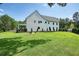 Lush backyard with a well-maintained lawn, rear view of a home, mature trees, and a fire pit area at 100 Chateau Pl, Woodstock, GA 30188