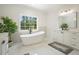 Bright bathroom featuring a soaking tub under a window, vanity, and modern finishes at 100 Chateau Pl, Woodstock, GA 30188