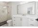 Modern bathroom with sleek vanity, large mirror, and a tiled shower with a glass door at 100 Chateau Pl, Woodstock, GA 30188