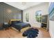 Stylish bedroom features a modern accent wall, plush rug, and natural light from two windows at 100 Chateau Pl, Woodstock, GA 30188