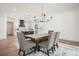 Elegant dining area featuring a rustic wood table, stylish chairs, and modern chandelier adjacent to the bright kitchen at 100 Chateau Pl, Woodstock, GA 30188