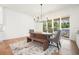 Dining room featuring wooden table with bench seating, a modern chandelier, and access to outdoor patio at 100 Chateau Pl, Woodstock, GA 30188