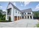 Beautiful modern farmhouse with a three-car garage, large driveway, and cozy front porch at 100 Chateau Pl, Woodstock, GA 30188