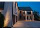 Exterior view of a modern home at twilight with three-car garage and covered front porch at 100 Chateau Pl, Woodstock, GA 30188