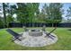 Stone fire pit area features Adirondack chairs creating a cozy spot for outdoor gathering in the backyard at 100 Chateau Pl, Woodstock, GA 30188