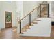 Elegant foyer with hardwood floors, staircase with metal railings, and natural light at 100 Chateau Pl, Woodstock, GA 30188