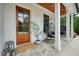 Inviting front porch with comfortable seating, wood ceiling, and a stylish wood door at 100 Chateau Pl, Woodstock, GA 30188