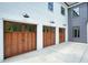 The property includes a spacious three-car garage with wooden doors at 100 Chateau Pl, Woodstock, GA 30188