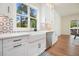 Kitchen sink with white cabinets, marble countertops, stainless steel dishwasher, and view of the backyard at 100 Chateau Pl, Woodstock, GA 30188