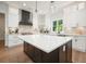Bright kitchen featuring a large island with marble countertop, stainless steel appliances, and sleek modern lighting at 100 Chateau Pl, Woodstock, GA 30188