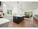 Open-concept kitchen with center island, stainless appliances, farmhouse sink, and seamless flow to the dining area at 100 Chateau Pl, Woodstock, GA 30188