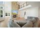 Cozy living room boasts a stone fireplace, large gray sectional, and a view to the second-floor loft at 100 Chateau Pl, Woodstock, GA 30188
