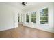 Sunlit living room with hardwood floors and large windows, perfect for relaxing or entertaining at 100 Chateau Pl, Woodstock, GA 30188
