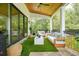 Outdoor covered patio featuring plush seating, faux turf, and stylish decor at 100 Chateau Pl, Woodstock, GA 30188