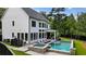 A backyard oasis featuring a modern home with pool, jacuzzi, and lounge chairs at 100 Chateau Pl, Woodstock, GA 30188