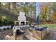Backyard with a fireplace, stone patio, seating area, and manicured landscaping at 4070 Whitewater Creek Nw Rd, Atlanta, GA 30327