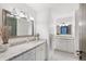 Bright bathroom featuring a granite countertop, white cabinets, and large mirrors at 4070 Whitewater Creek Nw Rd, Atlanta, GA 30327