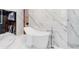 Luxurious bathroom featuring a soaking tub, marble floors and walls, and a large walk-in closet at 4070 Whitewater Creek Nw Rd, Atlanta, GA 30327