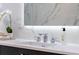 Bathroom vanity featuring a sleek faucet, decorative accents, and a marble backsplash for a luxurious feel at 4070 Whitewater Creek Nw Rd, Atlanta, GA 30327
