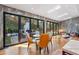 Sunlit dining area featuring modern chairs, hardwood floors, and sliding doors leading to a landscaped outdoor space at 4070 Whitewater Creek Nw Rd, Atlanta, GA 30327