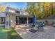 Exterior of house showing back patio with fireplace, seating, and lush landscaping at 4070 Whitewater Creek Nw Rd, Atlanta, GA 30327
