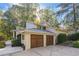 Exterior view of the home showcasing a two-car garage with attractive wooden doors and landscaping at 4070 Whitewater Creek Nw Rd, Atlanta, GA 30327