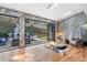 Elegant living room with hardwood floors and large glass doors opening to a beautiful outdoor patio and fireplace at 4070 Whitewater Creek Nw Rd, Atlanta, GA 30327