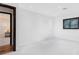 An empty white room with a window and adjacent room featuring hardwood floors at 4070 Whitewater Creek Nw Rd, Atlanta, GA 30327