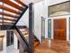Staircase features a mix of wood and dark elements with glass railings and modern fixtures at 4070 Whitewater Creek Nw Rd, Atlanta, GA 30327