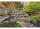 Inviting backyard space with a stone fire pit and mature trees, offering a serene setting for relaxation and gatherings at 5021 Heatherwood Ct, Roswell, GA 30075