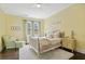 Charming bedroom with a chair and ottoman, complemented by natural light from the double windows at 5021 Heatherwood Ct, Roswell, GA 30075