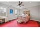 Bedroom with a red rug, canopy bed, desk, and two windows providing ample natural light at 5021 Heatherwood Ct, Roswell, GA 30075