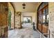 Covered front porch with stone columns and tile flooring, creating a cozy and inviting outdoor living space at 5021 Heatherwood Ct, Roswell, GA 30075