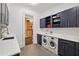 Well-equipped laundry room with modern washer and dryer, custom cabinets, and ample countertop space at 5021 Heatherwood Ct, Roswell, GA 30075