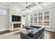 Bright living room with fireplace, coffered ceilings, large windows, and a comfortable blue wraparound sofa at 5021 Heatherwood Ct, Roswell, GA 30075