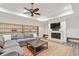 Living room with a fireplace, built-in shelving, ceiling fan, and a large comfortable couch at 5021 Heatherwood Ct, Roswell, GA 30075