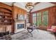 Wood-paneled office featuring custom built-ins, a fireplace, and views of the lush backyard at 5021 Heatherwood Ct, Roswell, GA 30075